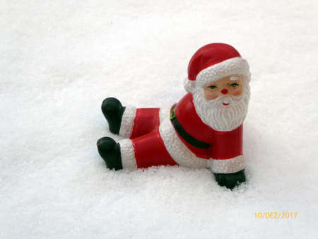 Ceramic santa claus on snow background. Lovely Merry Christmas and Happy New Year 2018 on snowfall background in Germanyの写真素材