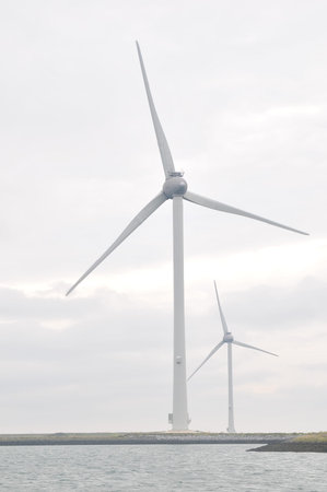 Wind turbine with cloudy sky and ocean