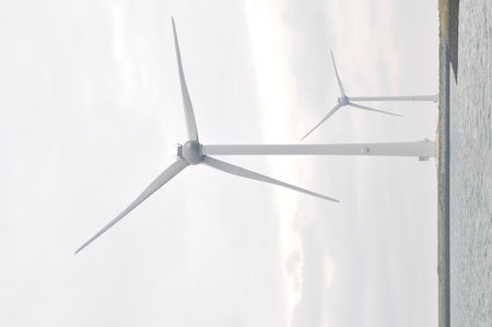 Wind turbine with cloudy sky and ocean