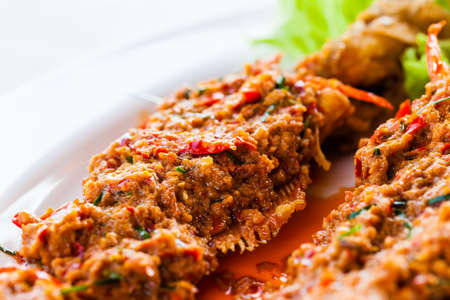 Close-up fried whisker sheat fish with chili sauce, or chili sauce on fried fish on white dish, Thai foodの写真素材