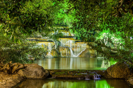 Waterfall with light from lamp in night gardenの写真素材