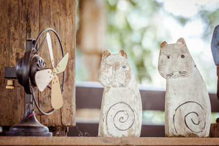 two wood carving cats with old fansの写真素材