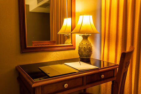 notebook on the table with lamp and chair in retro styleの写真素材