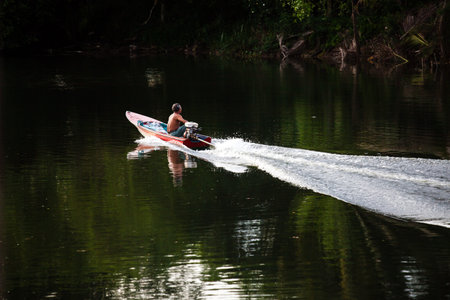 fisherman on the small boat at riverの写真素材