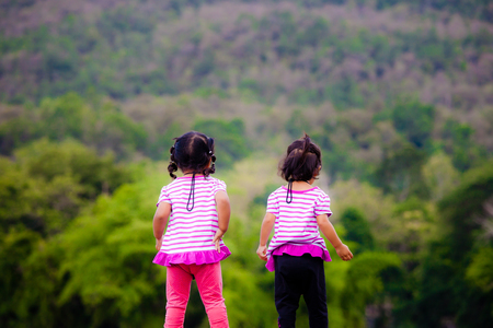 Rear view of two little girl at parkの写真素材