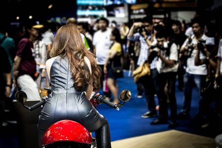 Closeup sexy back of young pretty woman sitting on motorcycle and photographer take a picture in backgroundの写真素材