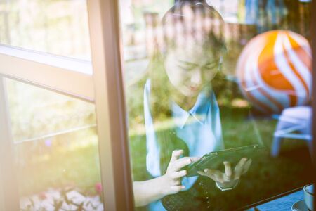 Young woman using tablet in cafe. Focus is tabletの写真素材