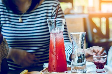 Beverage in beautiful flask with young woman in cafeの写真素材