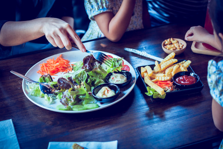 Salad on table with customer in cafeの写真素材