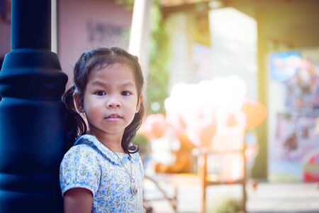 Asian little girl standing and looking in parkの写真素材
