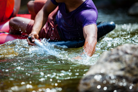 Close-up hand of young men is rafting on the river, extreme and fun sport at tourist attractionの写真素材