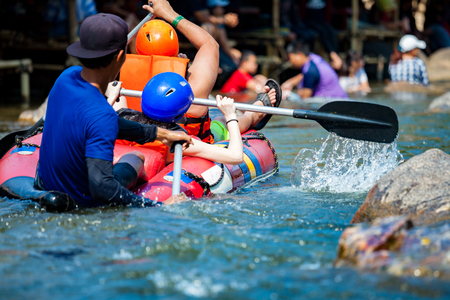 Young men and women are rafting on the river, extreme and fun sport at tourist attractionの写真素材