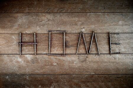 Alphabet made from nail on wooden background, word homeの写真素材
