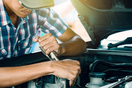 Cropped image of automobile mechanic repairing car in store, day timeの写真素材