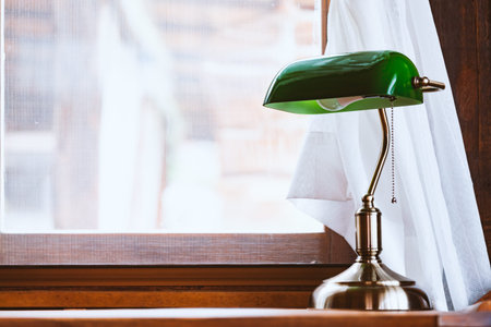 Vintage green lamp on table with window in day timeの写真素材