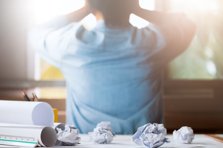 Close-up of crumpled paper on table with unhappy businesswoman was frustrated. Concept of no idea to...
