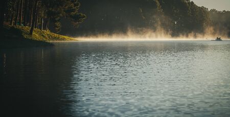 Pine forest with foggy over the reservoir while tourists rafting through the fog in the morning at Pang-ung, Mae Hong Son Province, North of Thailand.の写真素材