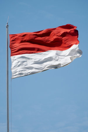 National flag of Indonesia waving in the wind against the blue sky.のeditorial素材