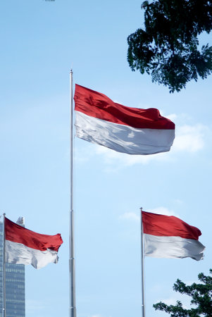 Indonesia flag waving in the wind with blue sky background.のeditorial素材