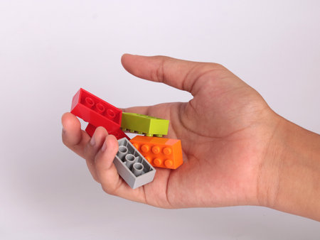 Hand holding building blocks on a white background. Isolated object.のeditorial素材
