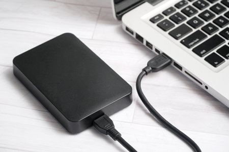 External hard drive and laptop on white wooden background. Top view.の写真素材