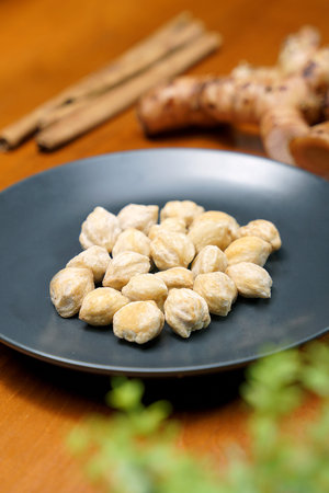 Hazelnuts in a black plate on a wooden table, horizontalの写真素材