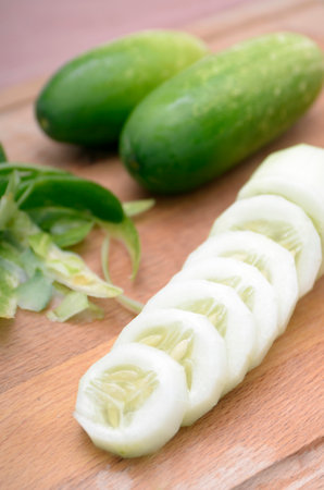 cucumber and sliced cucumber on wooden board, stock photoの写真素材