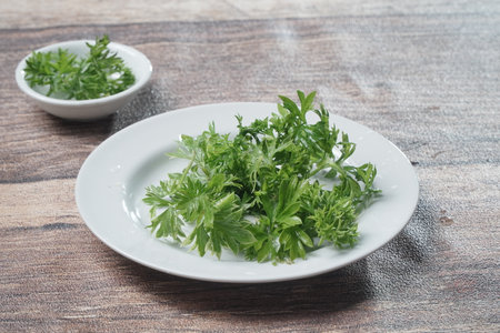 Fresh green parsley on a white plate on a wooden background.の写真素材