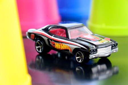 Diecast toys car, hotwheels, 1970 Chevell SS. 
Toy car with colorful plastic cups on a black background, close-upのeditorial素材