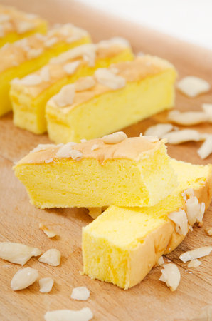 Piece of almond cake on wooden cutting board. Shallow dof.の写真素材