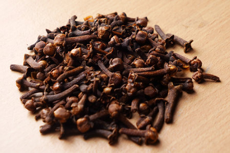 Heap of dried cloves on wooden background. Culinary spices.の写真素材