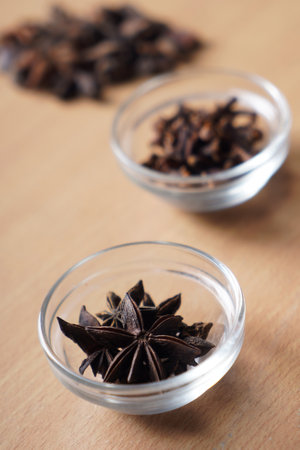Star anise spice in glass bowl on wooden background. Selective focus.の写真素材