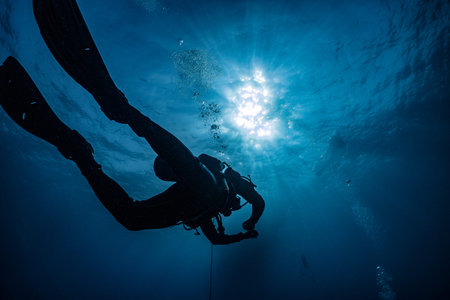 silhouette of scuba diver underwater in ocean