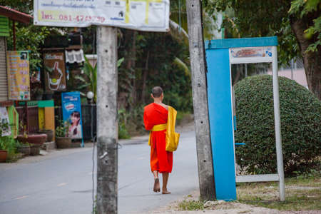 NOVEMBER 27, 2016 MAE SOT, THAILAND - monk with orange robe walking in the street in mae sot Thailandのeditorial素材