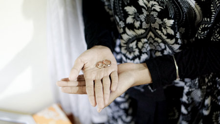 Close-up of woman's hands with wedding rings on her handの写真素材