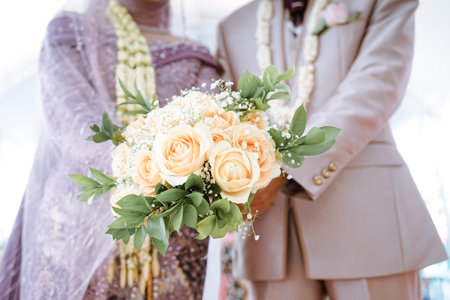 Bride and groom holding wedding bouquet of roses. Wedding in Thailandの写真素材