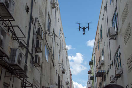 DRONE FLYING DJI BETWEN BUILDINGS IN A MOVIE PRODUCTION, SKY BACKGROUND 2020のeditorial素材