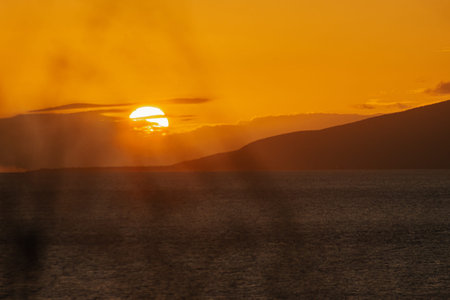 Magical golden sunset from Maui beach, sea and mountain background.