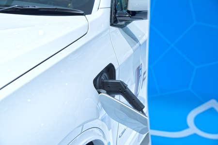 Electric car charging on parking lot with electric car charging station on city street. Electric cars in the row ready for charge.の写真素材