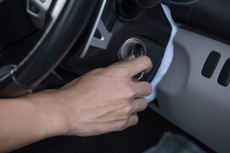 Close-up of a man's hand polishing a car door handleの写真素材
