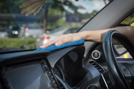 Hand with microfiber cloth cleaning interior car,cleaning car interior - car detailing and valeting conceptの写真素材