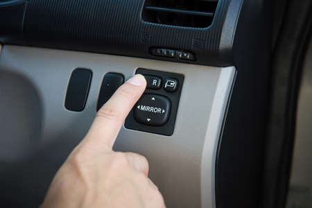 Close-up of a man's hand pressing the start button on the car doorの写真素材