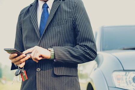 A man is using smartphone in asking for help when his car is broken,serious