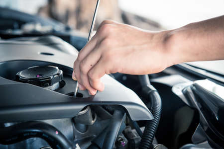 A man checking the auto engine,  uses a wrench to fix the car engine,repair service.の写真素材