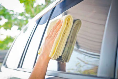 Worker cleaning  car with microfiber cloth, car detailing selective focus concept.の写真素材
