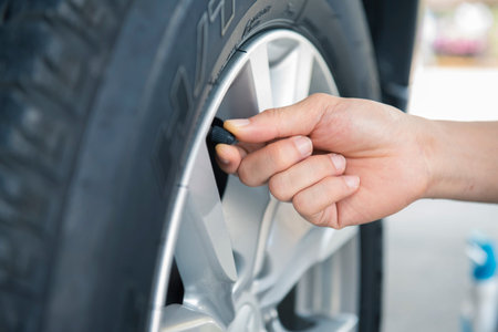 Close-up of a man changing a wheel of a car.の写真素材