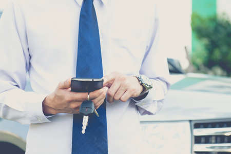 A man is using smartphone in asking for help when his car is broken,seriousの写真素材
