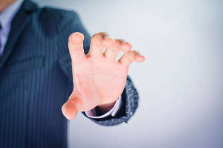 Businessman hand showing ok sign on grey background, close up.