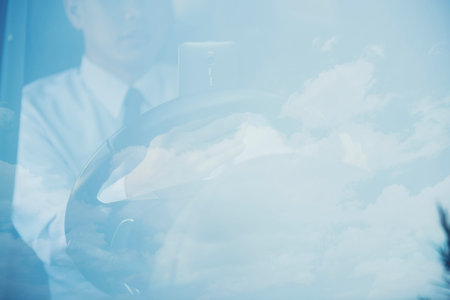 Businessman driving a car on the road with clouds in the background