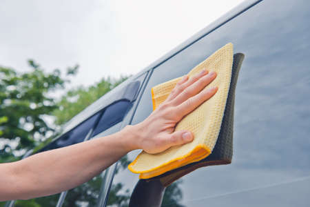 Worker cleaning  car with microfiber cloth, car detailing selective focus concept.の写真素材